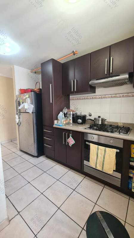 Modern kitchen with dark wood cabinetry, stainless appliances Plaza Valencia Panama