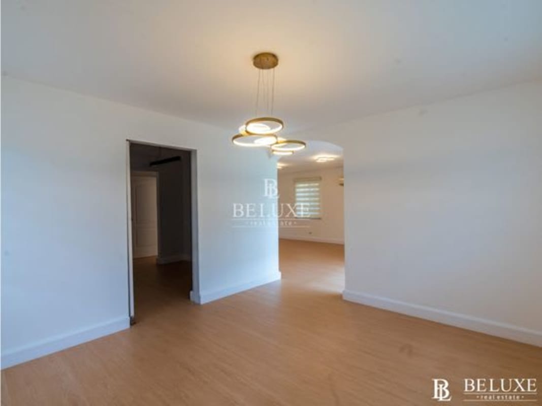 Modern bedroom with white closets, wood floors, striped blinds in Albrook Gardens Clayton
