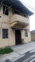Streetfront beige two-story guesthouse with balconies and grilled windows urban Penonomé Coclé Panama