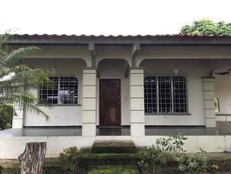 Single story gated house with covered porch arched columns and garden Santiago Panama