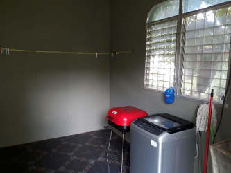 Blue water storage tank with protective cover in fenced backyard Santiago Panama
