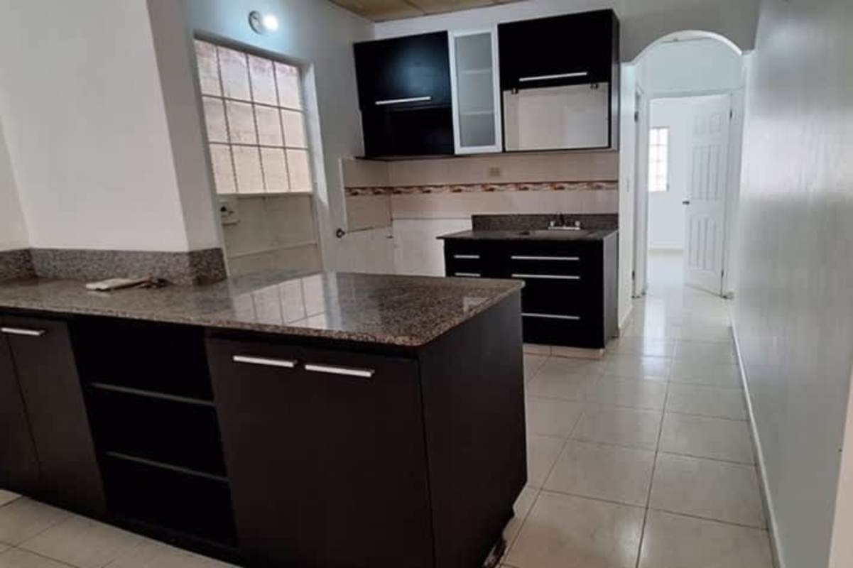 Black and white modern kitchen with granite counters at Don Bosco house in Panama City