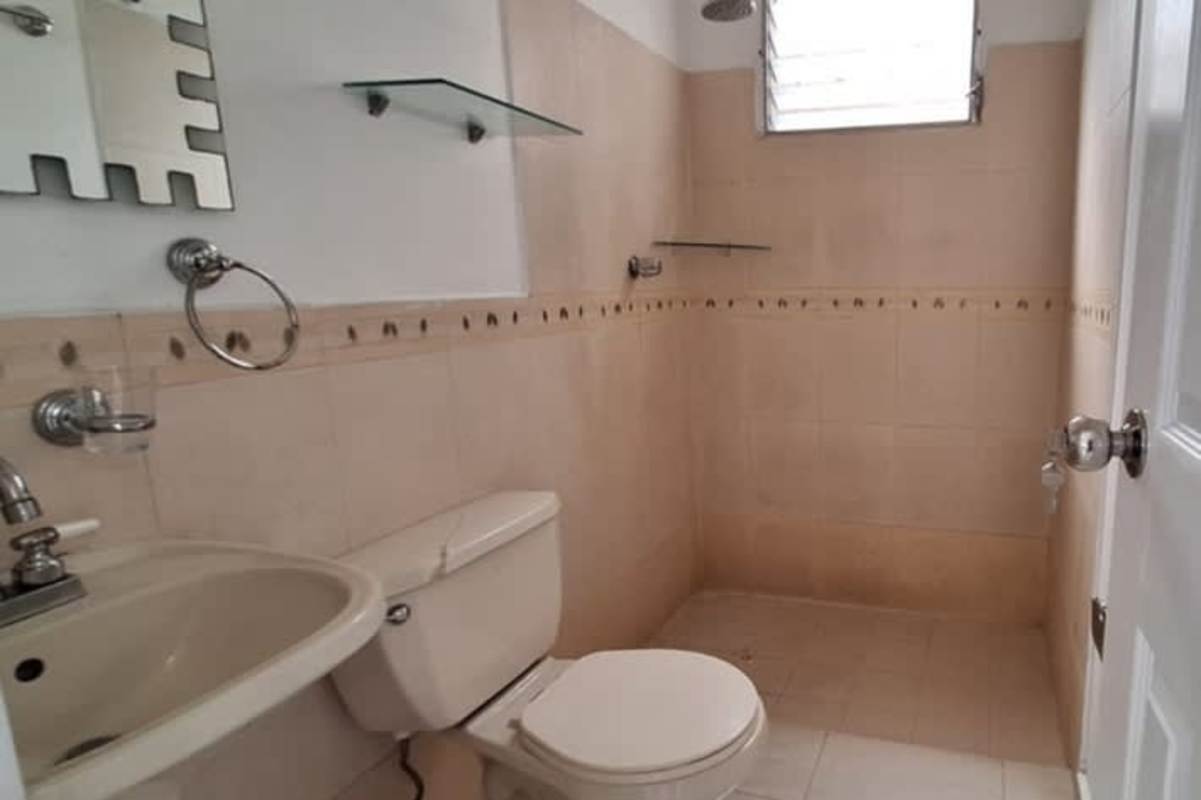 Bathroom with beige tiles, shower, mirror, shelf at Don Bosco house for sale