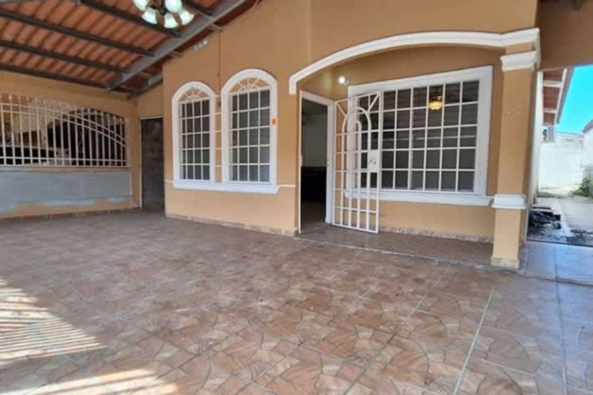 Front porch of Don Bosco house with covered tiled patio and security gate