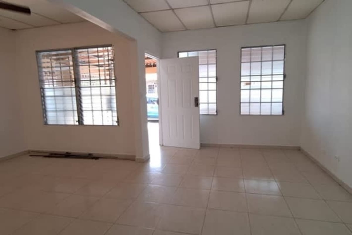 Living area with tiled floors and grid windows with bars at Don Bosco home