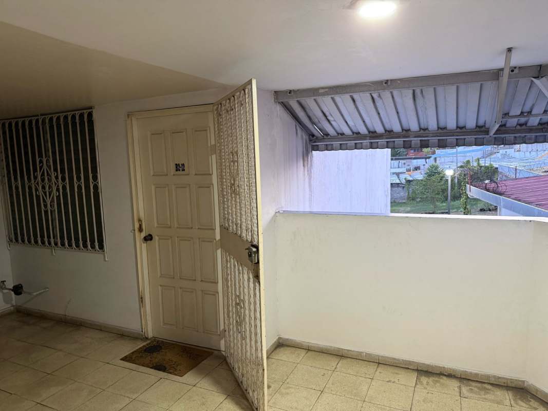 Covered apartment entry with security gate and cream wooden door at Beverly Plaza Rio Abajo Panama