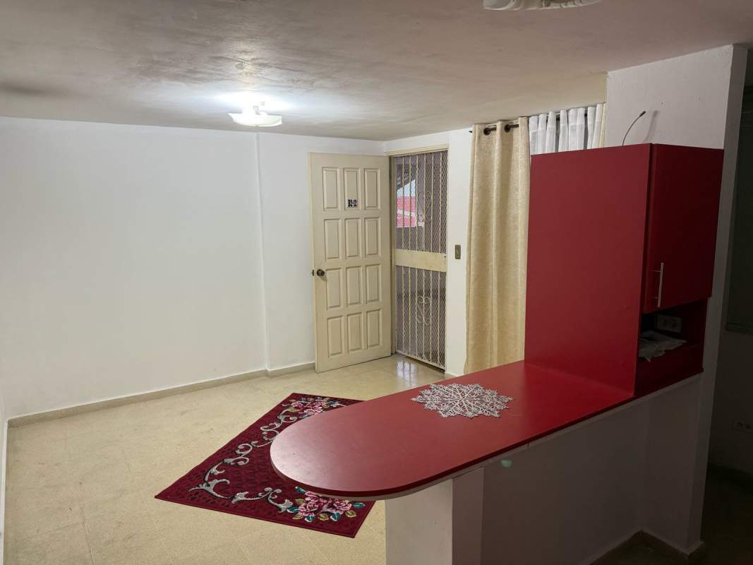 Living area combined with open kitchenette featuring red countertop at Beverly Plaza Panama