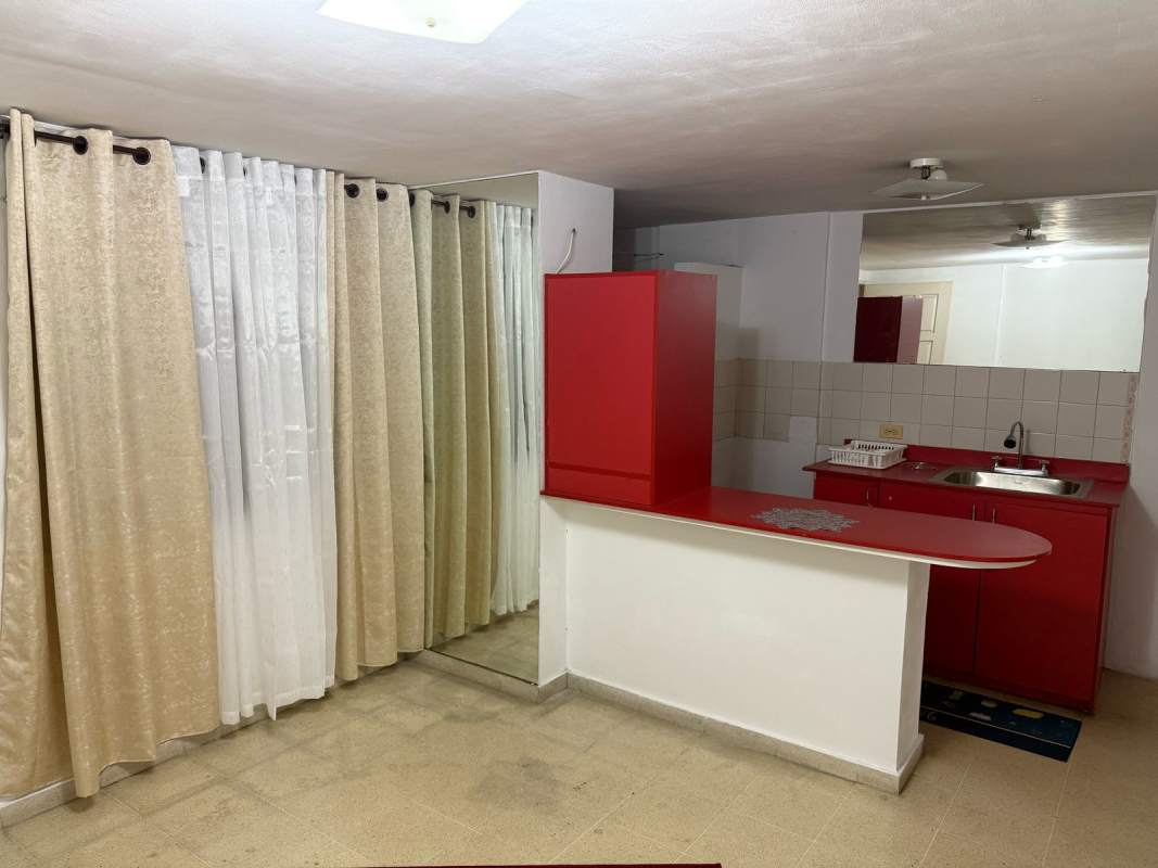 Compact modern kitchen with red breakfast bar countertops in Beverly Plaza Rio Abajo Panama City