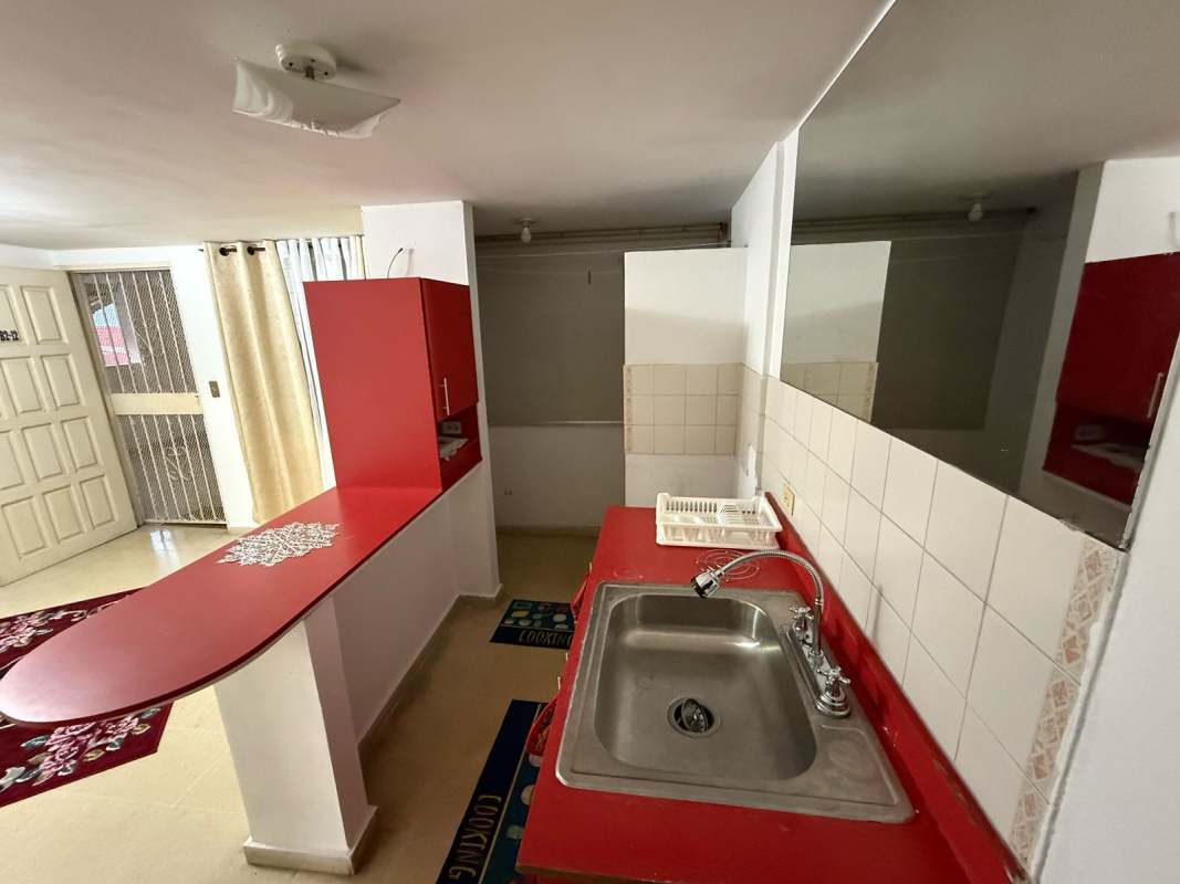 Kitchen area with red counters, cabinets, and breakfast bar at Beverly Plaza Panama City