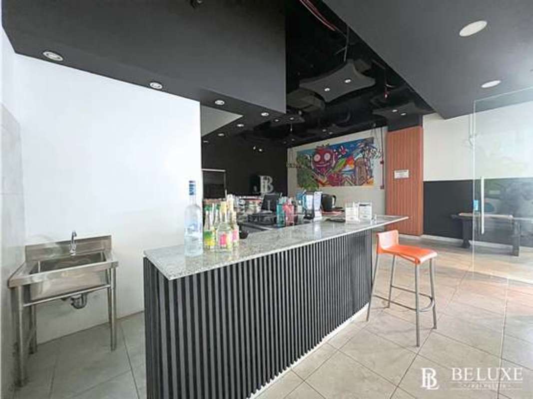 Granite bar counter, colorful mural, industrial lighting in commercial space Avenida Balboa Panama City
