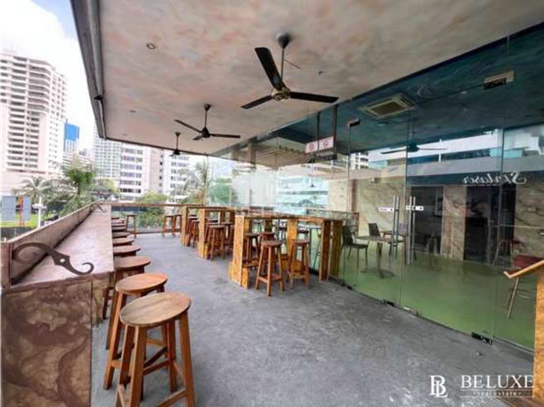 Outdoor rooftop terrace dining with glass walls and city views, Avenida Balboa Panama