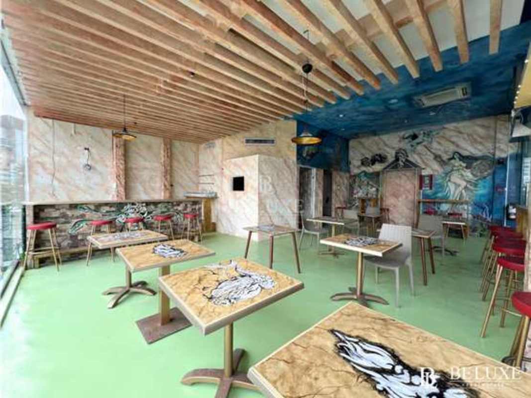 Eclectic restaurant space with murals, bar counter, pendant lighting, Panama City