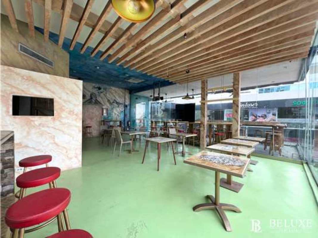 Modern restaurant dining interior with wood ceiling, colorful murals, glass wall in Panama