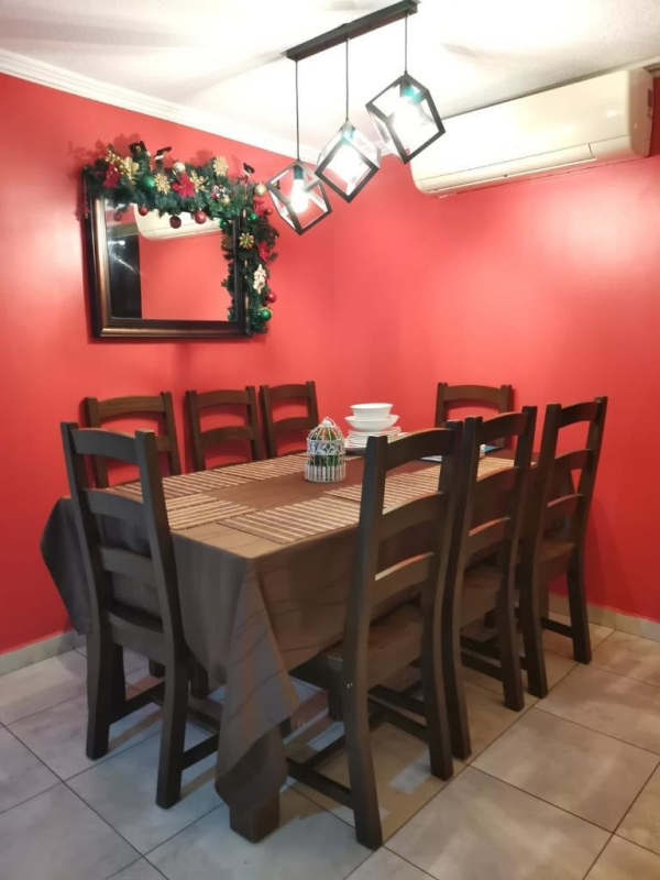 Dining room area with red walls, pendant lighting, wooden dining table and AC in Parque Lefevre Panama