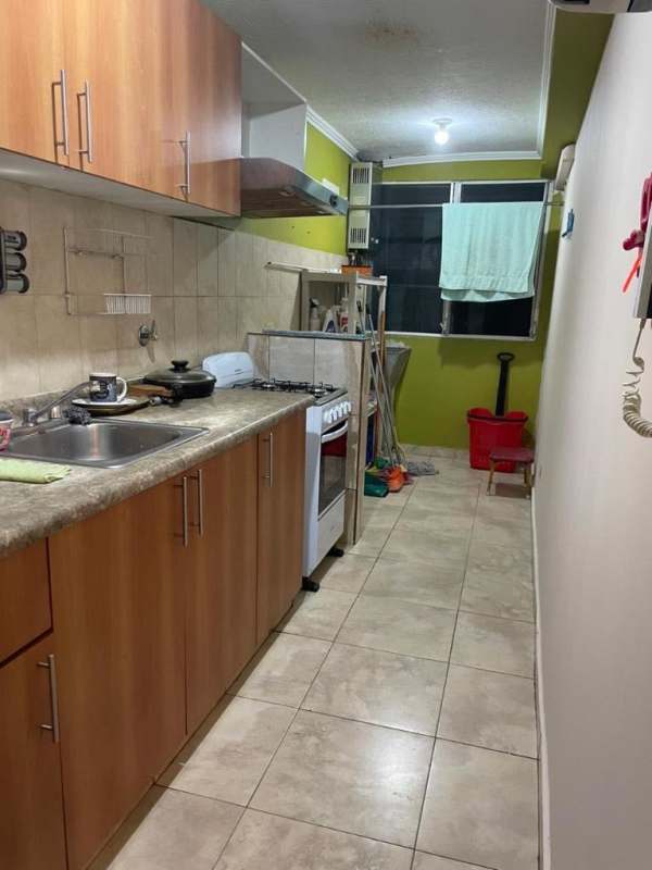 Narrow kitchen with wooden cabinetry, gas stove and tile backsplash in PH Los Girasoles Panama City