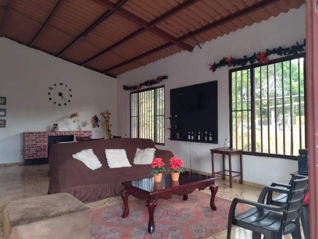 Large open living room with red accent wall exposed ceiling country house Pacora Panama