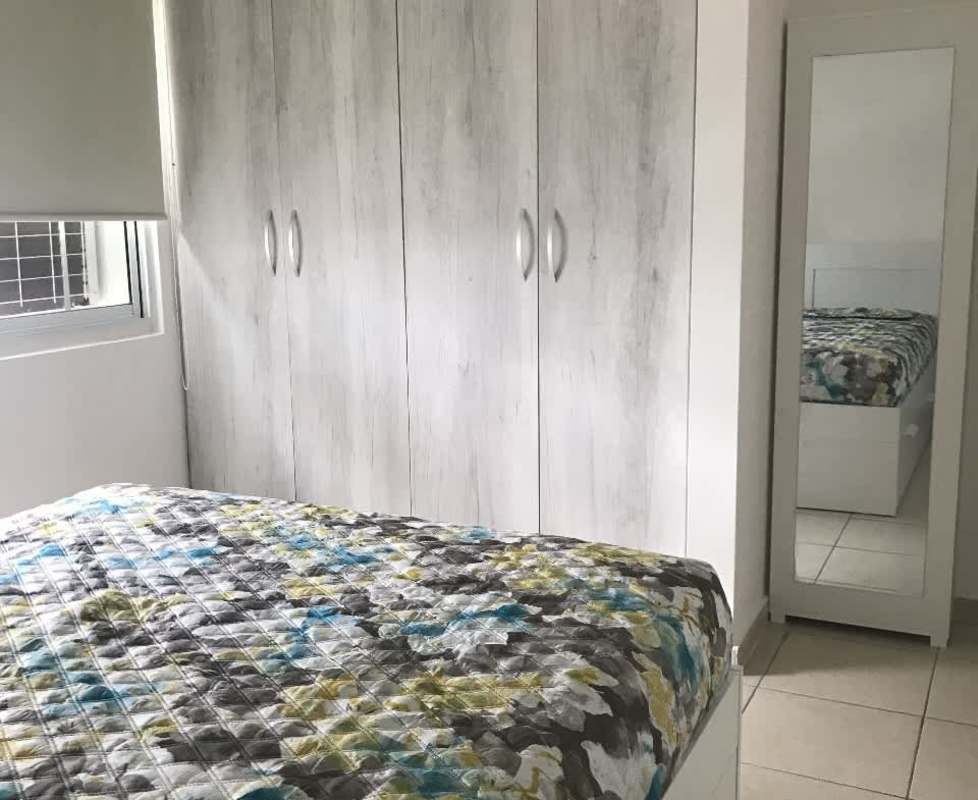 Modern bedroom with wardrobe mirror and window city view in PH Cangrejo Central Panama