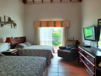 Bright bedroom with balcony striped bedding natural light Villas Decameron Panama for sale