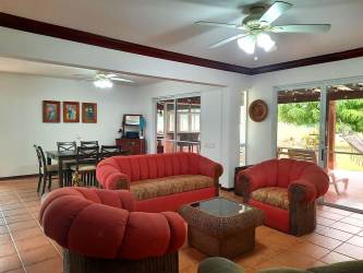 Spacious bedroom with wooden bed ceiling fan large window in villas Decameron Farallón Panama