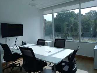 Modern meeting room with large windows, conference table, chairs, TV screen at Costa Verde Business Hub Panama