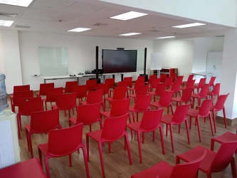 Modern conference room with rows of red chairs, large screen and whiteboards in Costa Verde Panama