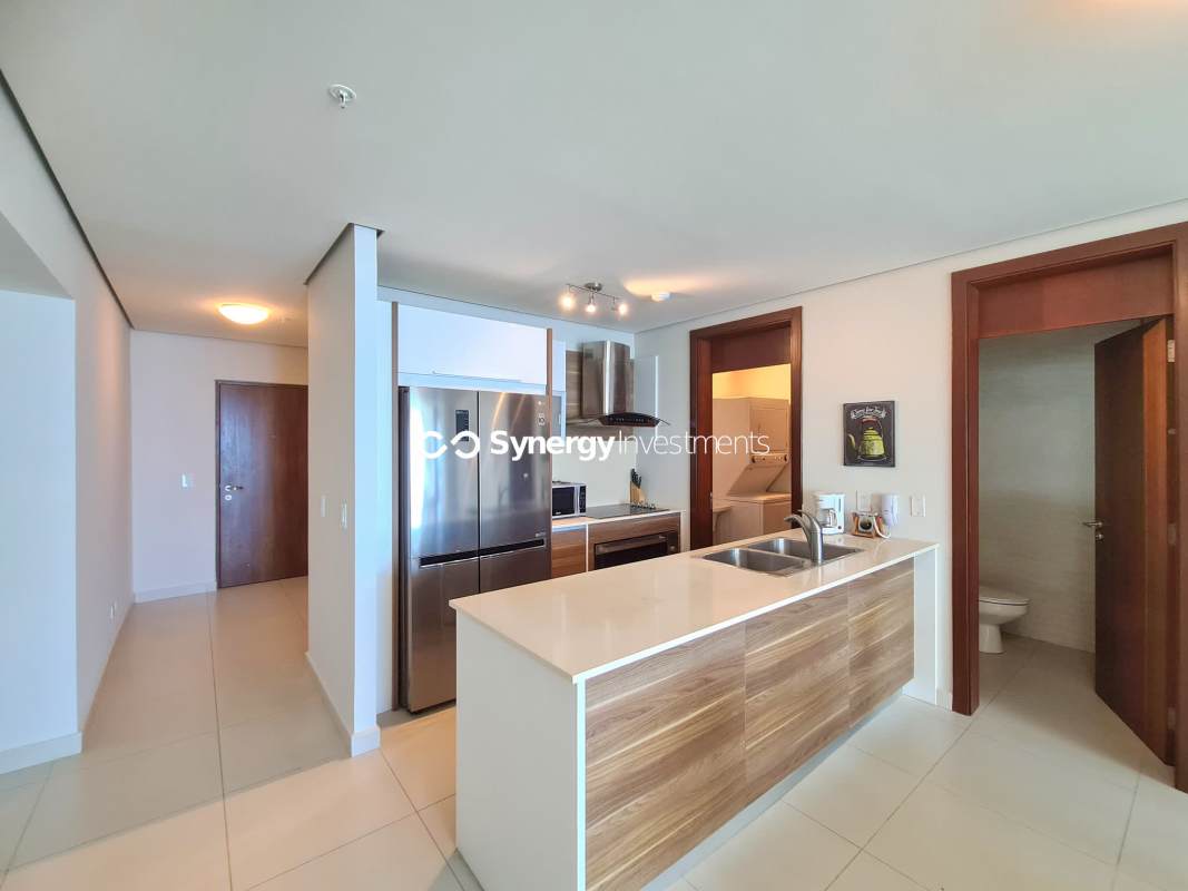 Kitchen with island, wood cabinets, stainless appliances at PH Parkside Costa del Este Panama