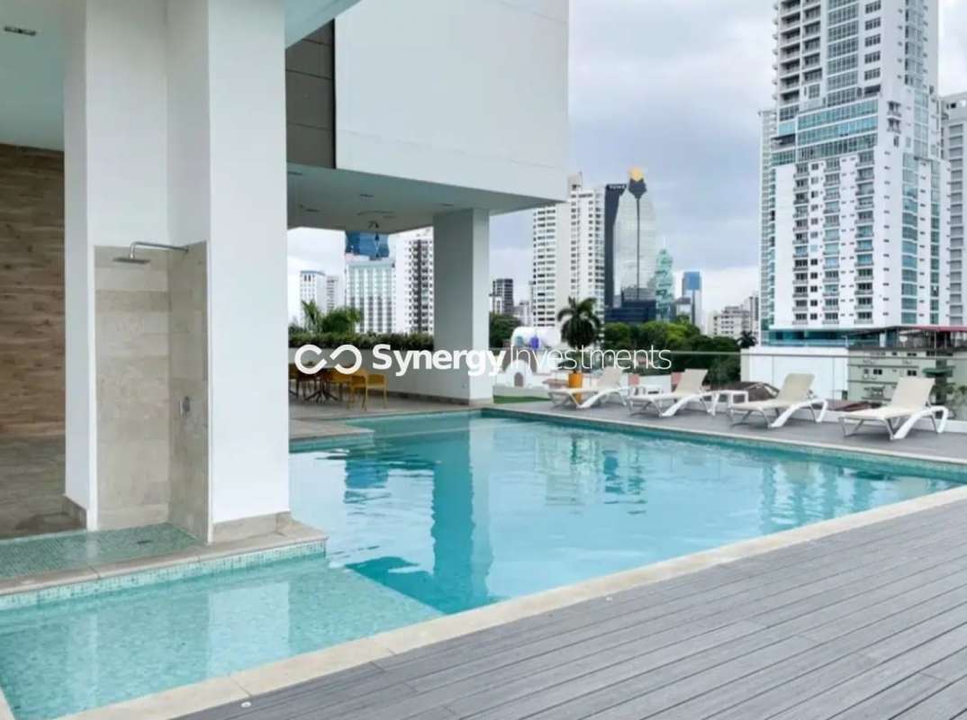 Rooftop swimming pool with sun loungers and city skyline view in PH Bellavista Tower Panama City