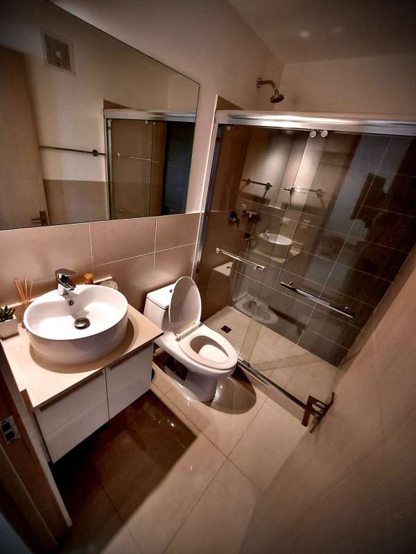 Bathroom with glass-enclosed walk-in shower, vanity, and mirror PH South Coast