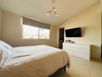 Minimalist bedroom with window, tile floor, built-in closet in Panama Pacifico Howard