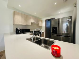 Kitchen featuring stainless steel appliances, light cabinetry, granite counters in Panama Pacifico Howard house