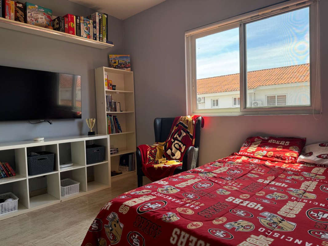 Bedroom with colorful accent wall, large window in Costa Sur Panama