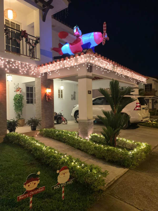 Modern entrance hallway with wood floor, stairs, glass doors in Quintas de Versalles house Panama City