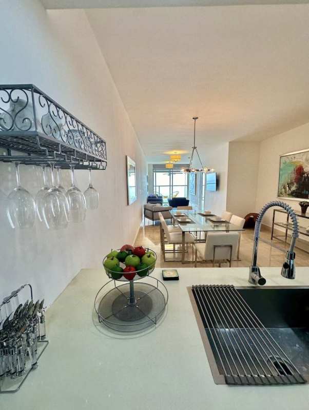 Open dining area with glass table, pendant lights, modern decor PH Yoo apartment Panama City