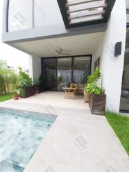 Outdoor covered terrace overlooking private pool and garden in Panama Pacifico home