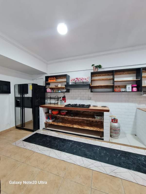 Rustic style kitchen with white subway tiles, wooden counters, shared space La Loceria Panama