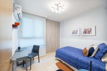 Bedroom with blue bedding, desk, wall art Parterre Panama Pacifico