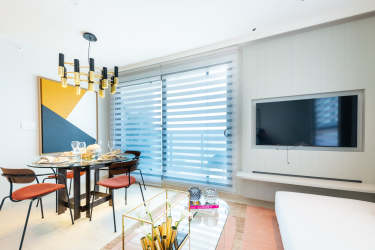 Dining room with modern chandelier, decorative plants, round table Parterre Panama