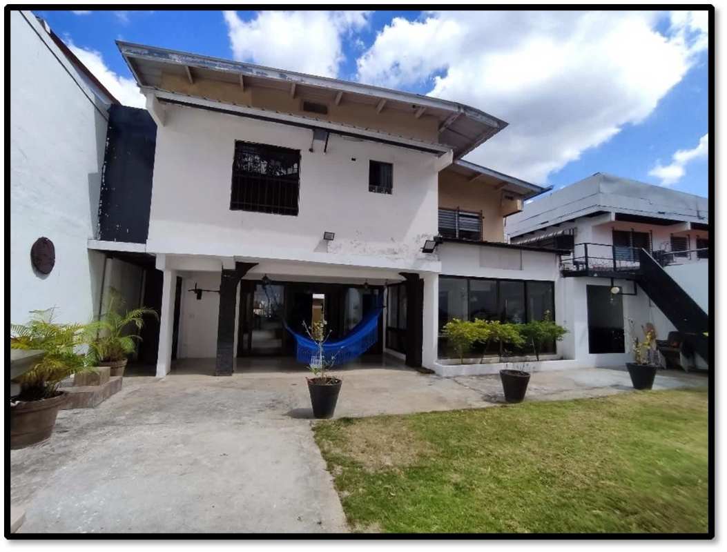 Spacious kitchen with black cabinetry, granite island and built-in appliances in house El Dorado Panama