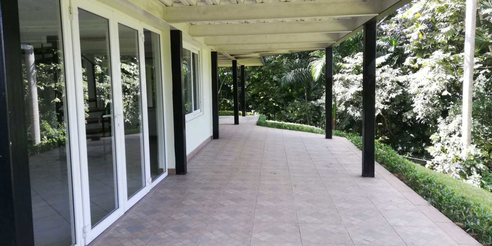 Living and kitchen open plan tile floors exposed beams windows Cerro Ancón Panama