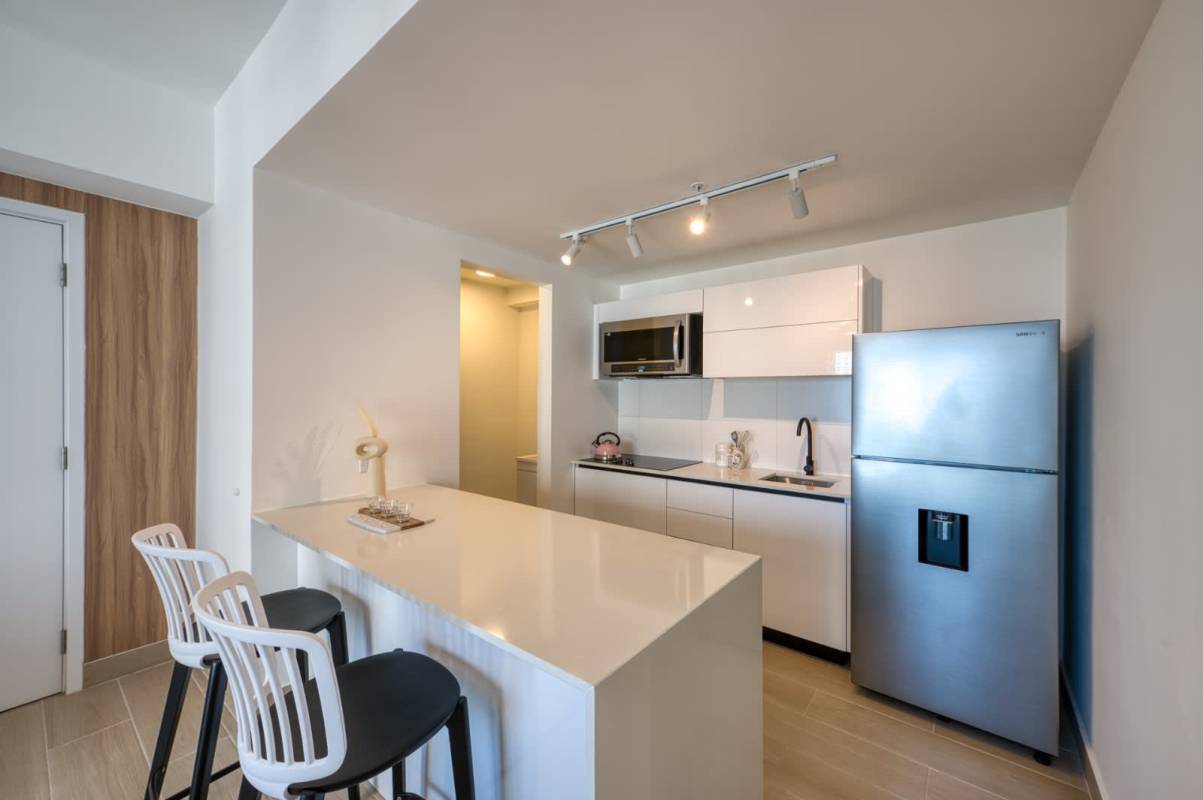 Minimalist reception lobby at PH Mantra with designer lighting and cream textured walls in Panama City