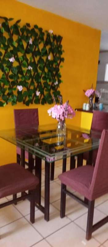 Dining space with yellow wall, green decor and glass table in PH Vía España Obarrio Panama City
