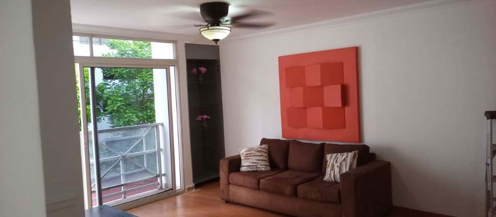 Stylish furnished living space with sofa, shelving, city balcony access in Argentina Tower Panama City