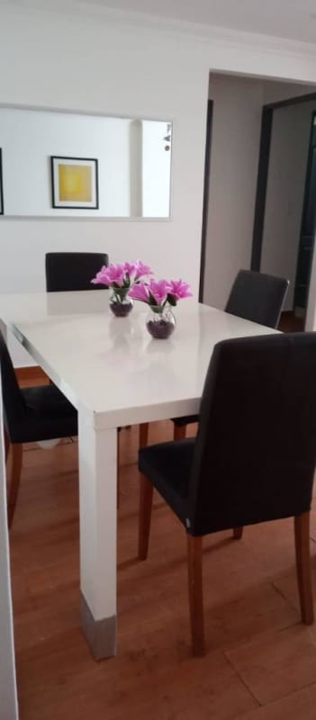 Contemporary dining area with white table, black chairs, wall art, large mirror in Argentina Tower Panama