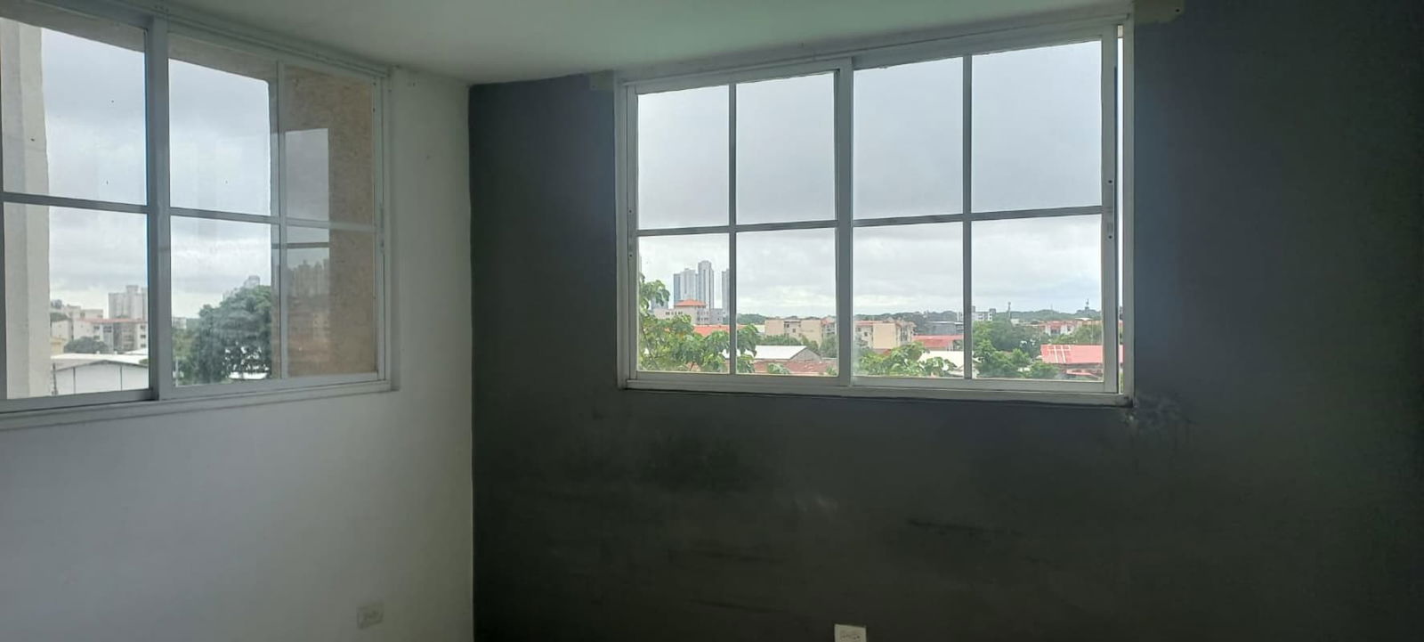 Bedroom with corner windows offering city view cloudy skyline PH Río de Oro Panama