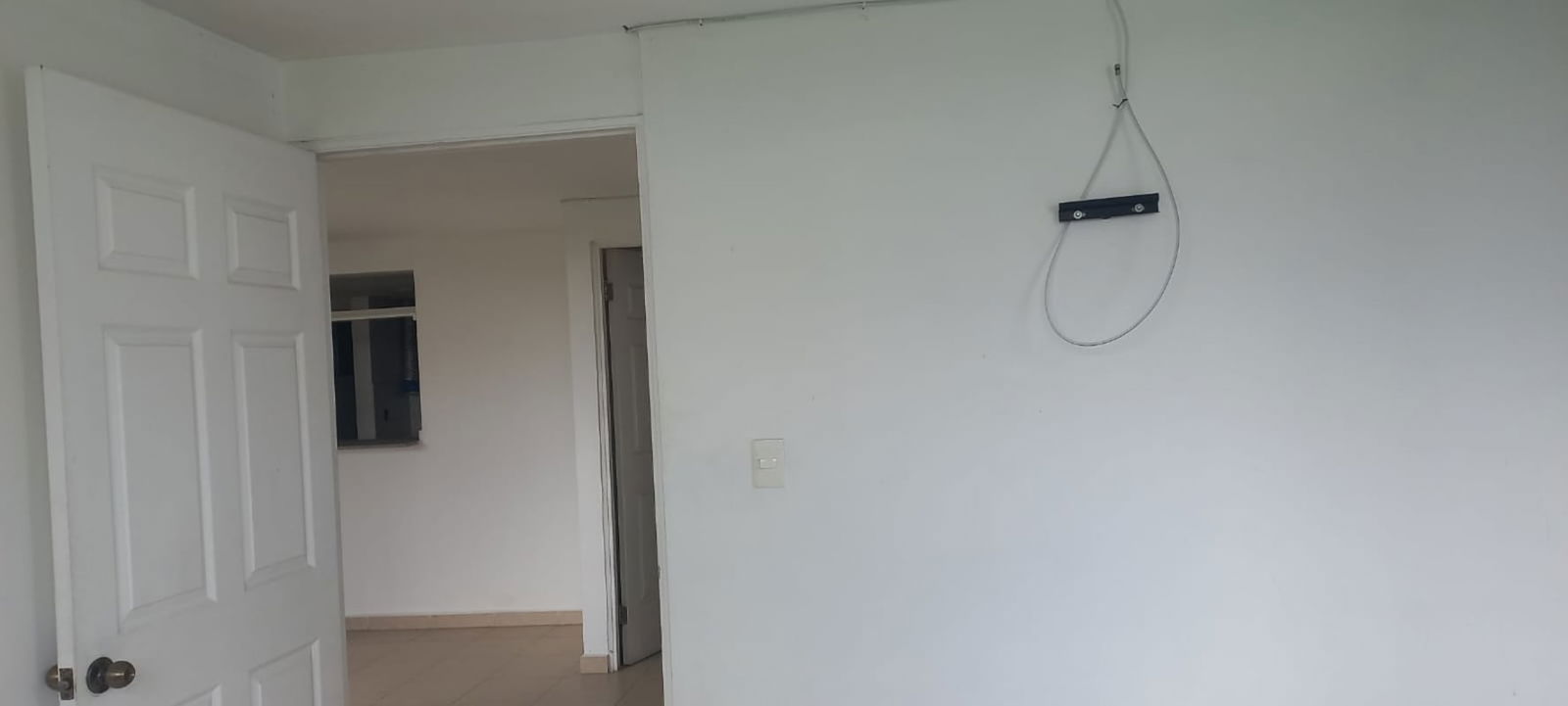 Bedroom with wall mount bracket, tile floor and white walls in PH Río de Oro Panama