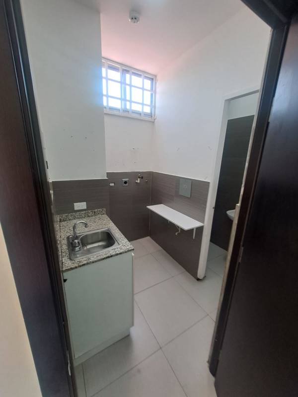 Utility room with granite countertop sink window and white tiles in commercial space Panama