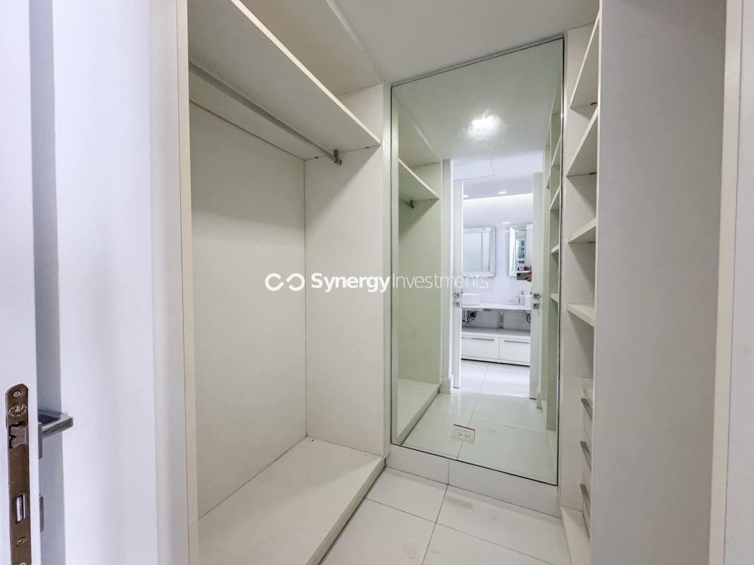Spacious master bedroom with floor-to-ceiling windows, marble floors, and walk-in closet at luxury condo YOO Panama