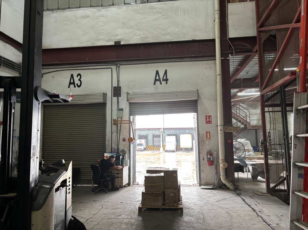 Interior storage warehouse with high ceiling and shelving racks in Las Cumbres Panama City