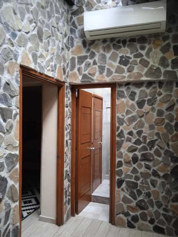 Rustic hallway with stone-clad walls, wooden doors, split AC La Cresta apartment Panama City