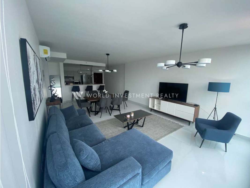 Contemporary living space with blue sectional sofa and large window city views in PH Top Tower Panama